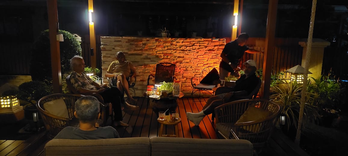 Family relaxing and talking together on the patio at night